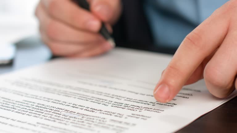Close up of hand signing document